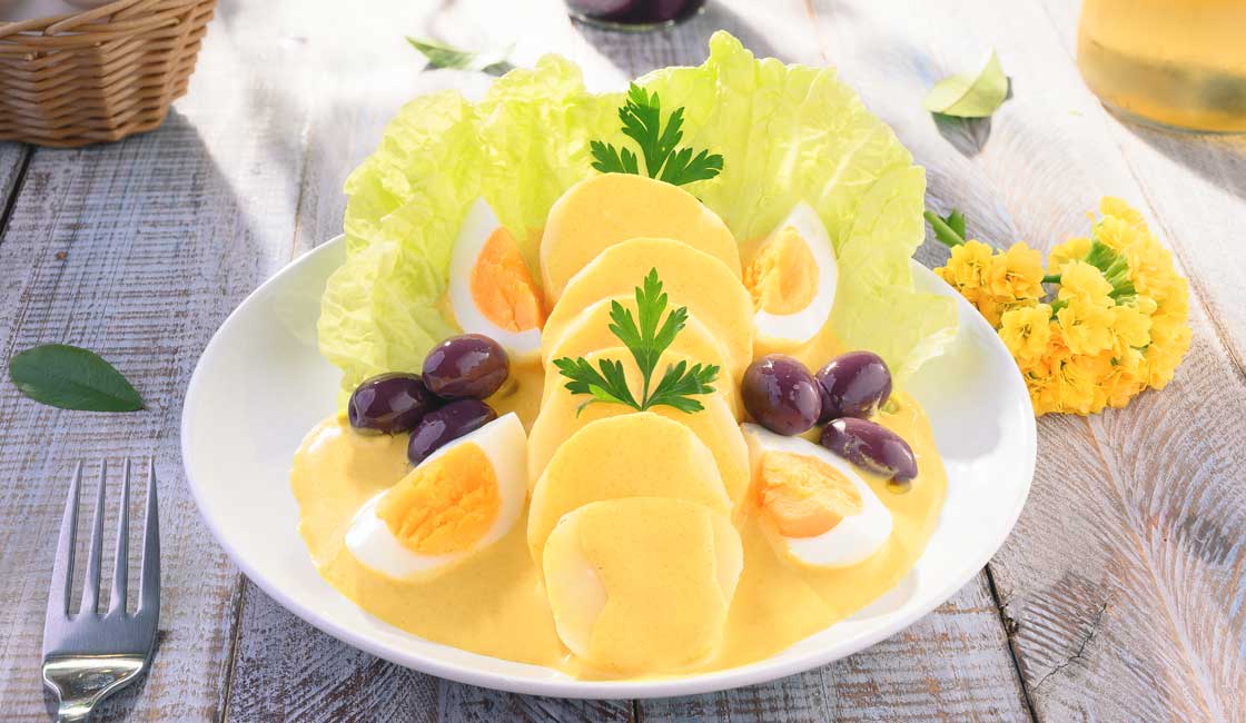 Haşlanmış yumurtaların bir tarafı ile patateslerin üzerine sarı sos