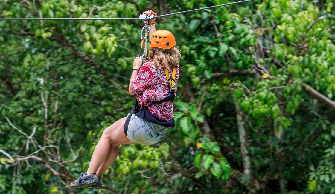 A girl zip-lining in the forest