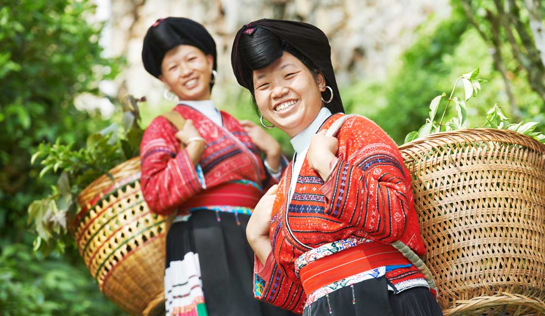 Two Yao women carrying baskets