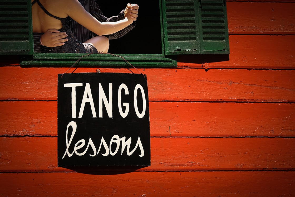 Tango dersi işareti ve dans eden çift