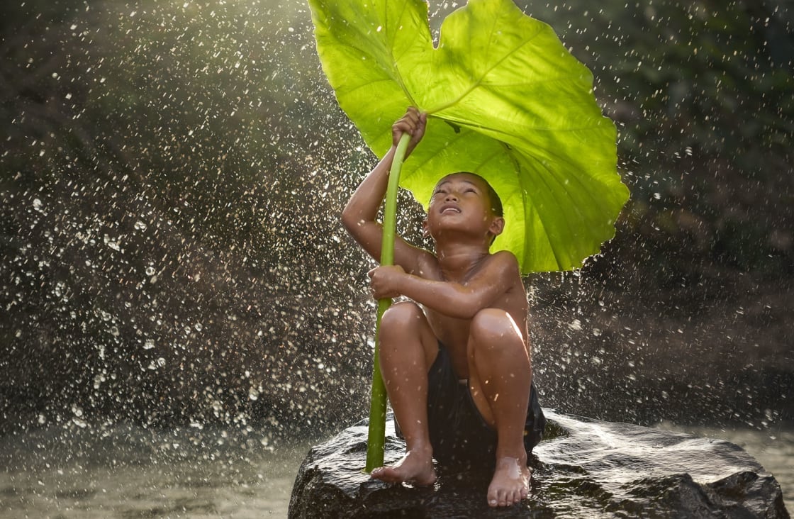 yağmurda dev bir izinle oynayan çocuk